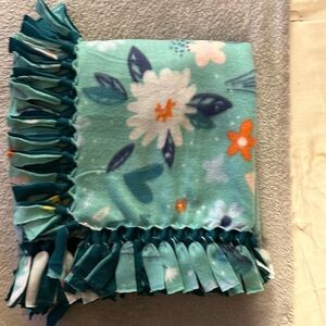 50x60” fleece tie blanket.  Floral pattern fleece with teal fleece backing.
